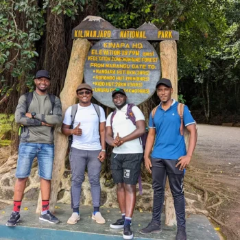 a group of men standing in front of a sign