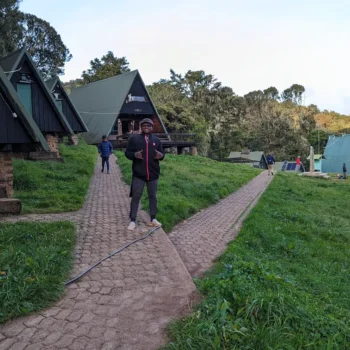 a man standing on a path with a couple of houses in the background