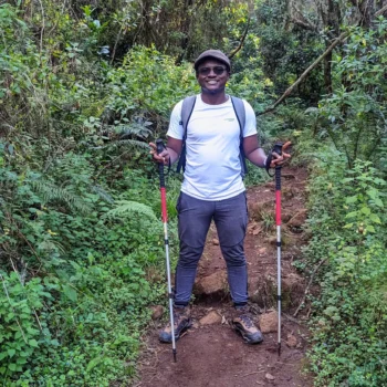 a man standing on a trail with poles